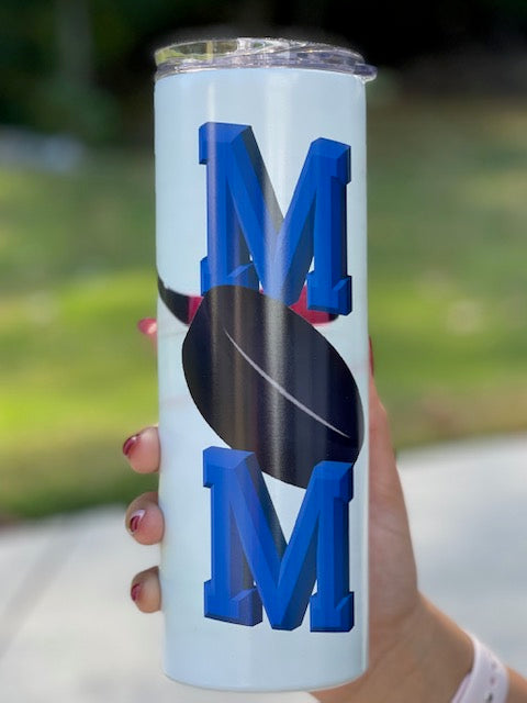 20oz tumbler, with  Mom with a hockey puck as the o with a hockey stick in the back ground. the Ms are blue.