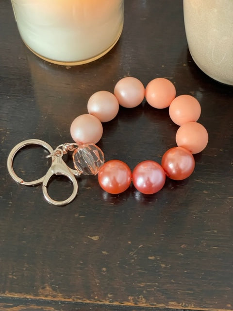 This bracelet features ten 20mm peach and coral bubble gum beads in a ombre arrangement a rose gold swivel lobster clasp keyring.