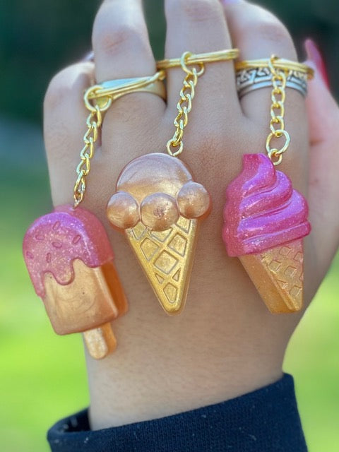 This is 3 different keyring. one is a dipped ice pop. the other is a scooped  ice cream on a waffle cone and the third is a soft serve strawberry ice cream on a waffle cone.